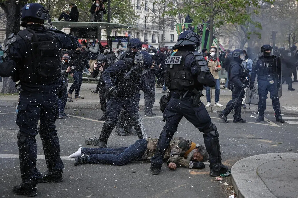 Riot police surround a man amid clashes with protesters in Paris over government pension reform., on March 28, 2023.