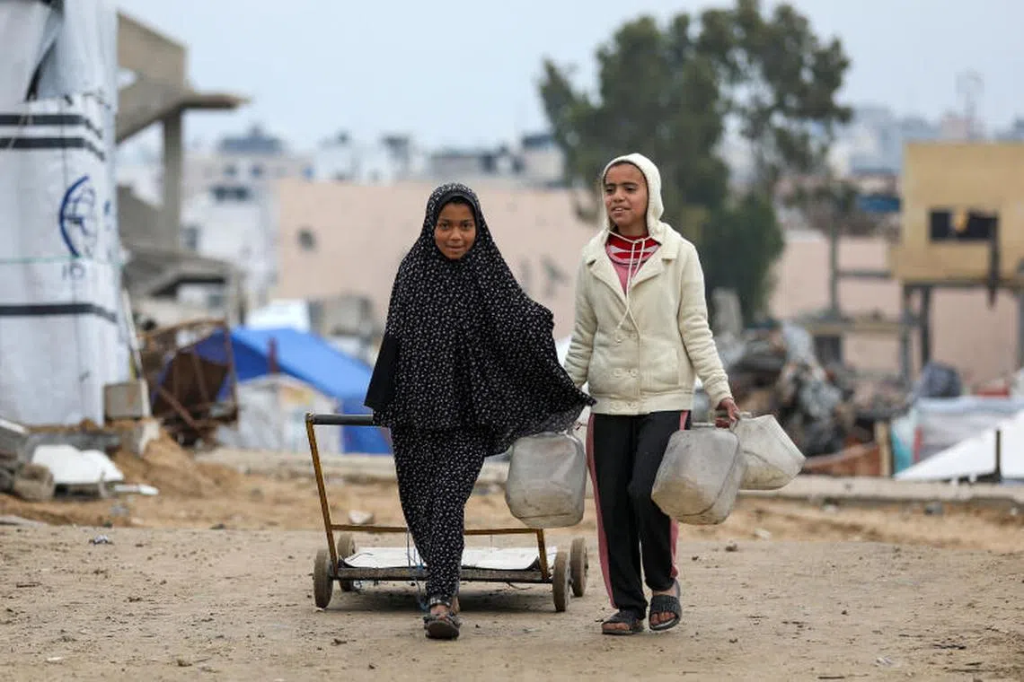 Palestinian girls walk to collect water, amid a ceasefire between Israel and Hamas, in Gaza City February 22, 2025. REUTERS/Dawoud Abu Alkas