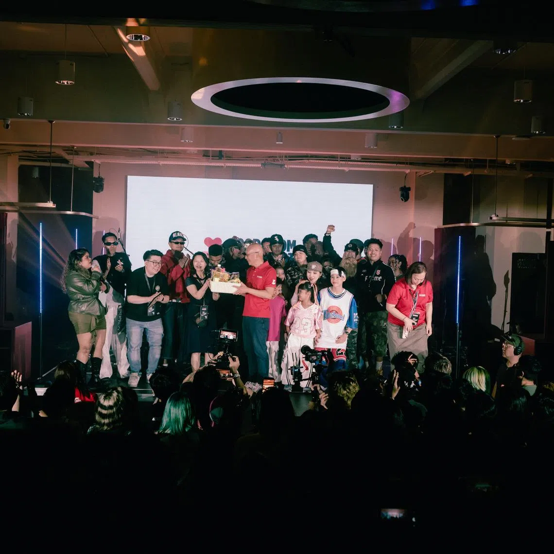 Chief executive of food charity Food From The Heart Robin Lee receiving food items on stage at Beatback, representing the donations made by concertgoers on June 28.