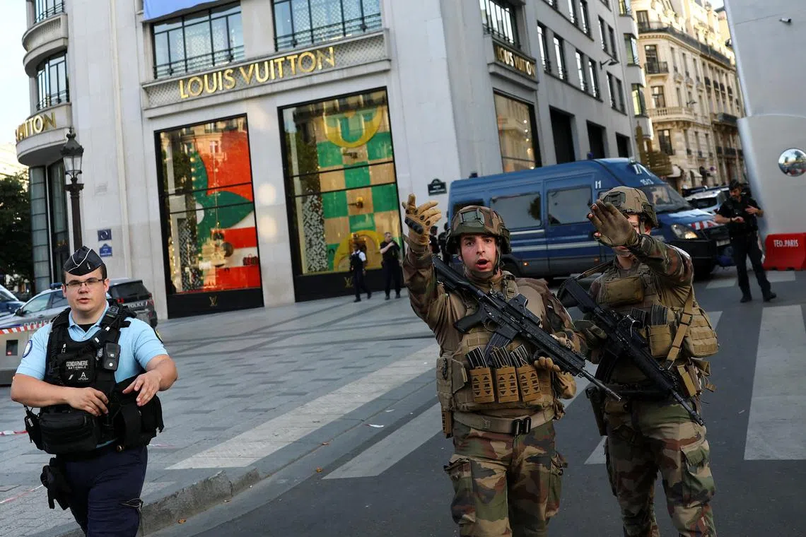 French soldiers standing guard after a police officer was injured in an attack next to Paris'  Champs-Elysees avenue, on July 18.