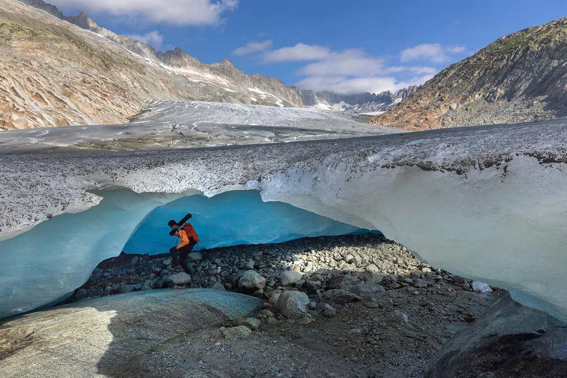 Matthias Huss, a glaciologist and head of the Glacier Monitoring in Switzerland (GLAMOS) entering an ice cave at the tongue of the Rhone glacier amid climate change in Obergoms, Switzerland, Aug 27, 2024.
