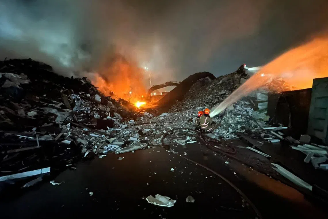 Firefighters battling a blaze at the premises of recycling and waste management firm Wah and Hua on March 28.