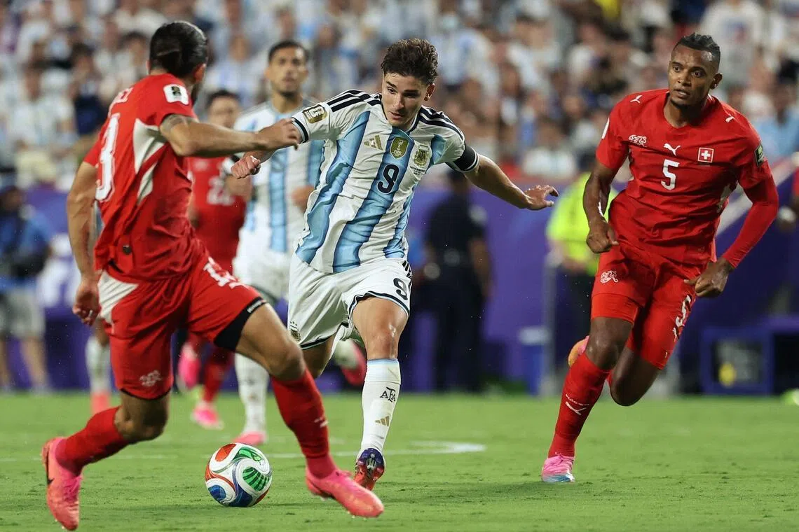 Argentina's forward #09 Julian Alvarez runs with the ball as Switzerland's defender #13 Ricardo Rodriguez and Switzerland's defender #05 Manuel Akanji defend during the 2026 World Cup football tournament quarter-final match between Argentina and Switzerland at the Kansas City Stadium in Kansas City on July 11, 2026.  (Photo by Thomas COEX / AFP)
