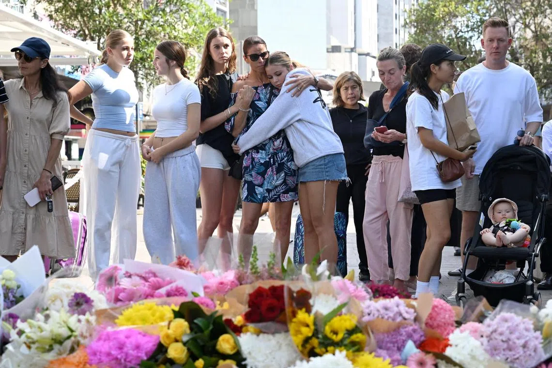 People react as they pay their respects at the scene of Saturday's mass stabbing at Bondi Junction, Sydney, Australia April 14, 2024. AAP Image/Dean Lewins via REUTERS  ATTENTION EDITORS - THIS IMAGE WAS PROVIDED BY A THIRD PARTY. NO RESALES. NO ARCHIVE. NEW ZEALAND OUT. NO COMMERCIAL OR EDITORIAL SALES IN NEW ZEALAND. AUSTRALIA OUT. NO COMMERCIAL OR EDITORIAL SALES IN AUSTRALIA  
