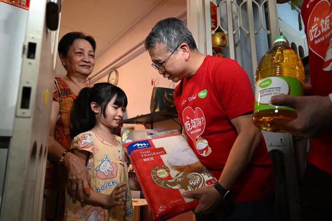 Slug: smfood03
ST PHOTO: Chong Jun Liang

Edwin Tong, Minister for Culture, Community and Youth and Second Minister for Law distributing rice and oil to Madam Ho Thi Dung, 69 (left) and her granddaughter Chua Qien, (centre) 10, on January 3, 2024.
