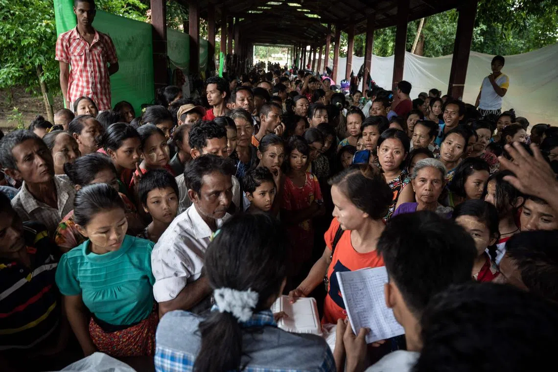 Residents displaced by flooding wait for food to be distributed as they take shelter in a monastery compound following monsoon rains in Bago township in Myanmar's Bago region on August 12, 2023. Floods and landslides caused by monsoon rains have killed five people and forced the evacuation of around 40,000 others in Myanmar, officials said on August 11. (Photo by Sai Aung Main / AFP)