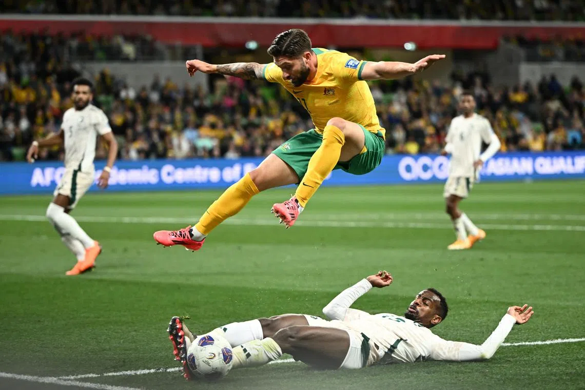 Abdullah Al-Khaibari of Saudi Arabia and Brandon Borrello of Australia challenging for the ball during their World Cup qualifier.