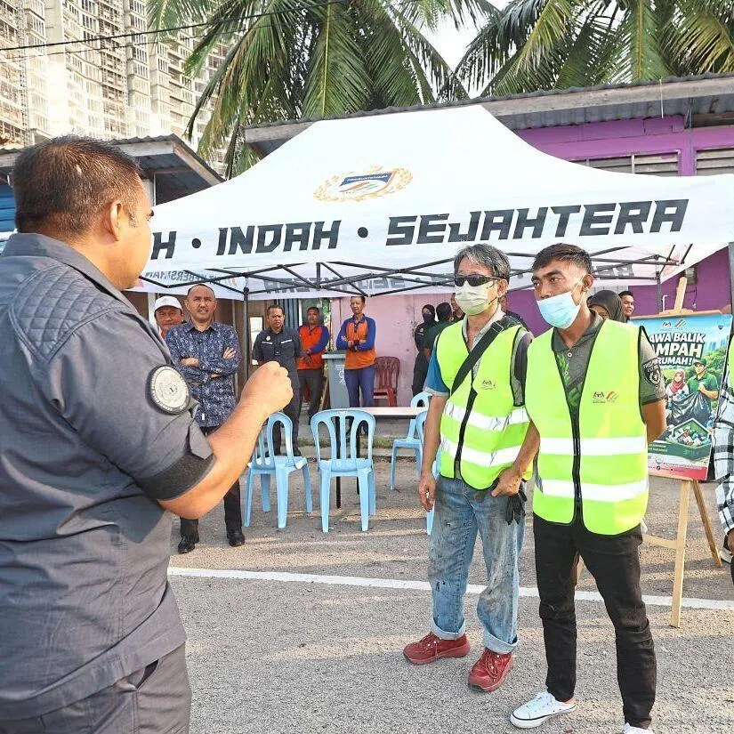 A Johor Solid Waste Management and Public Cleansing Corporation officer briefing three individuals before their community service in Johor Bahru.