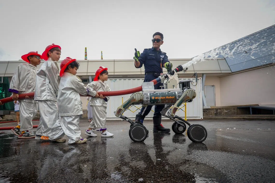 Children getting up close with a firefighting robot during RoboFest 2026 at the Science Centre Singapore on Apr 9, 2026. 