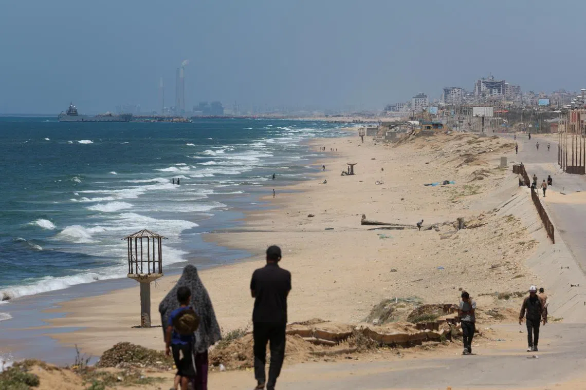 A ship is pictured off the coast of Gaza near a temporary floating pier anchored by the United States to boost aid deliveries, as seen from the central Gaza Strip May 16, 2024. REUTERS/Ramadan Abed