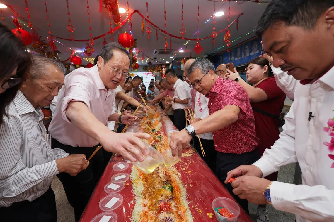 (Second From left): MPs of Marine Parade GRC, Dr Tan See Leng; and Mr Edwin Tong; taking part in lohei during the Geylang Cultural Organisations and Clan Associations Spring Reception 2025, on Feb 6, 2025.
