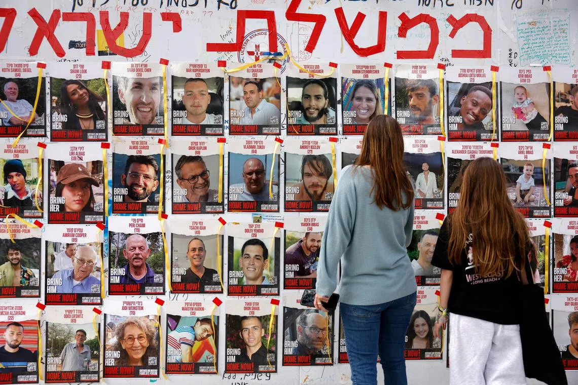A March 8 picture shows people in Israel's Tel Aviv looking at photos of hostages kidnapped in Hamas' deadly Oct 7 attack on the Jewish state.