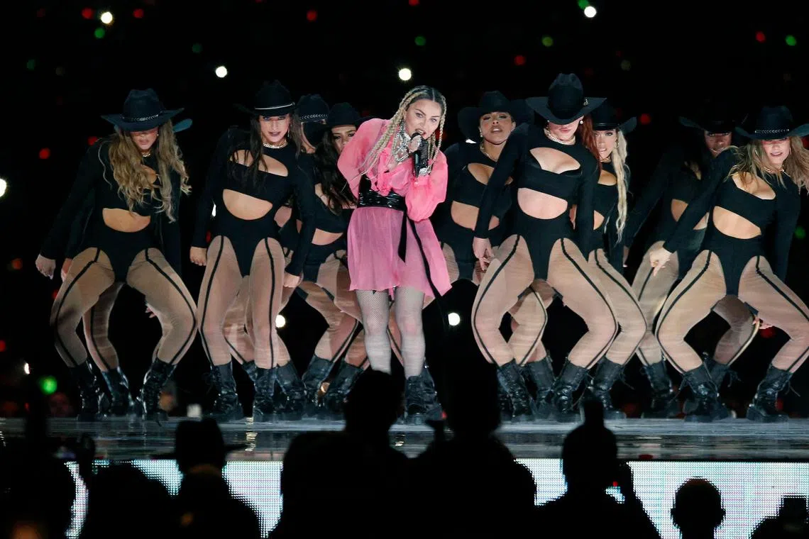 Pop icon Madonna (C) performs on stage with Colombian singer Maluma (out of frame) during his concert "Medallo in the Map", in Medellin, Colombia, on April 30, 2022. 