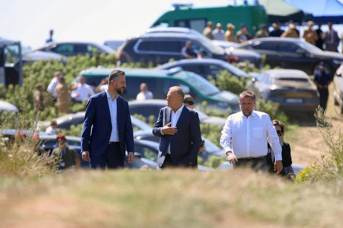 Polish Prime Minister Donald Tusk (centre) visiting the site of the missile impact on July 30, with Defence Minister Wladyslaw Kosiniak-Kamysz (left) and Interior Minister Marcin Kierwinski.