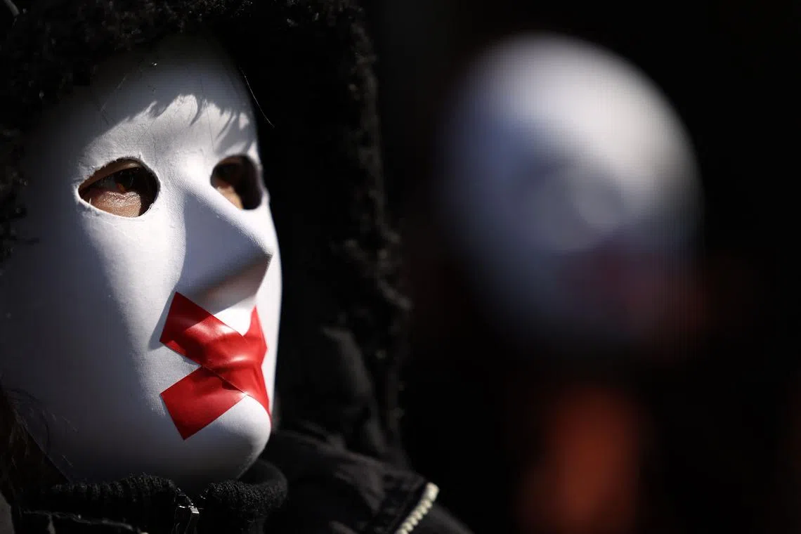 Activists posing for a photograph on College Green by the Houses of Parliament, in central London, on March 19, 2025, as they take part in a protest marking the first anniversary of the implementation of the Hong Kong National Security Ordinance Article 23. 