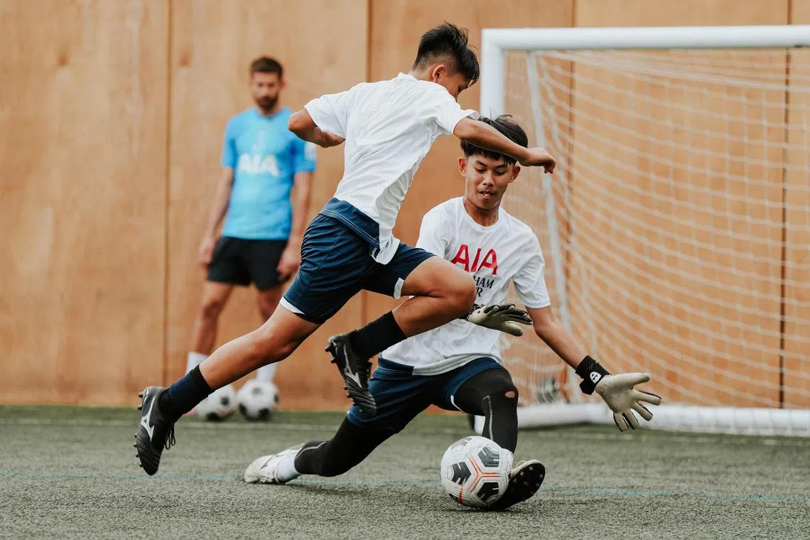 AIA Singapore–Spurs Elite Football Camp player Judah Koh taking on Hykel Morris at Tottenham Hotspur's training ground in Enfield, London.
