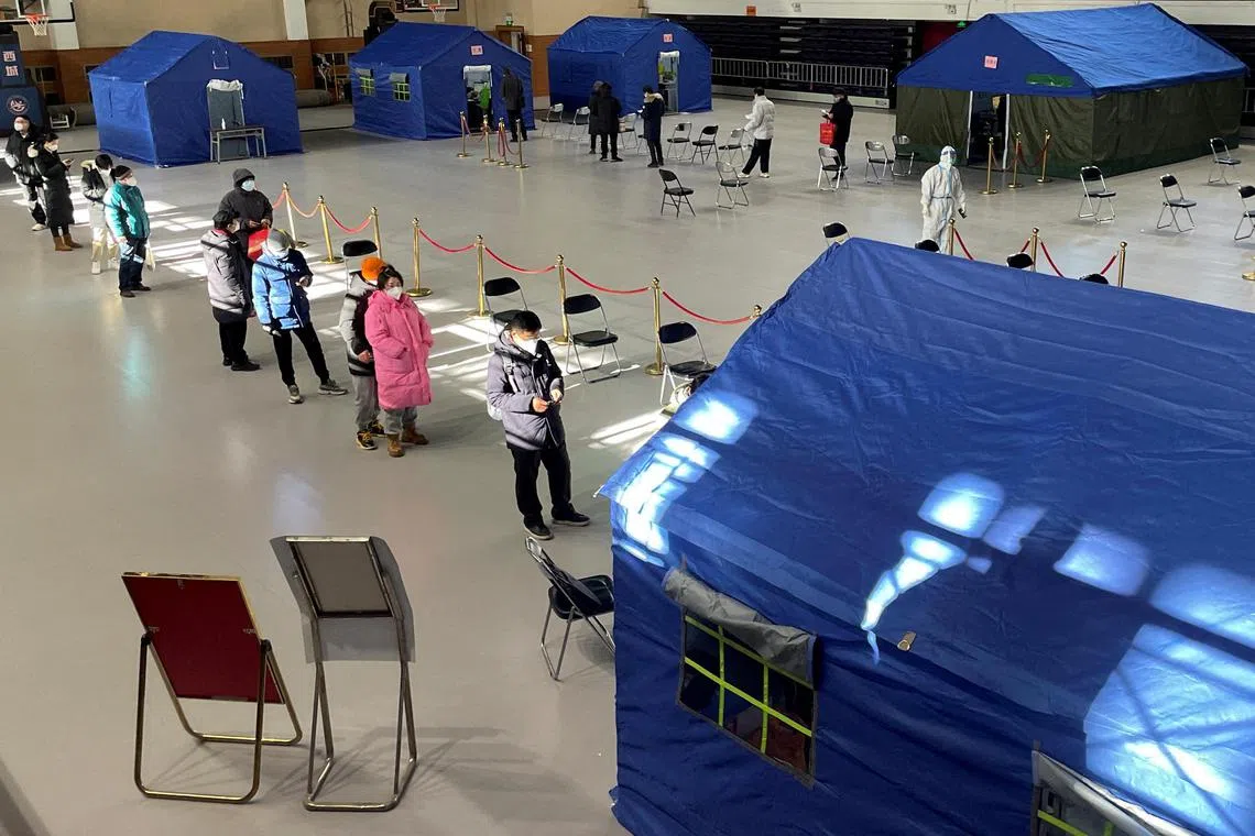 People queueing at a makeshift fever clinic set up inside a stadium in Beijing on Dec 19.