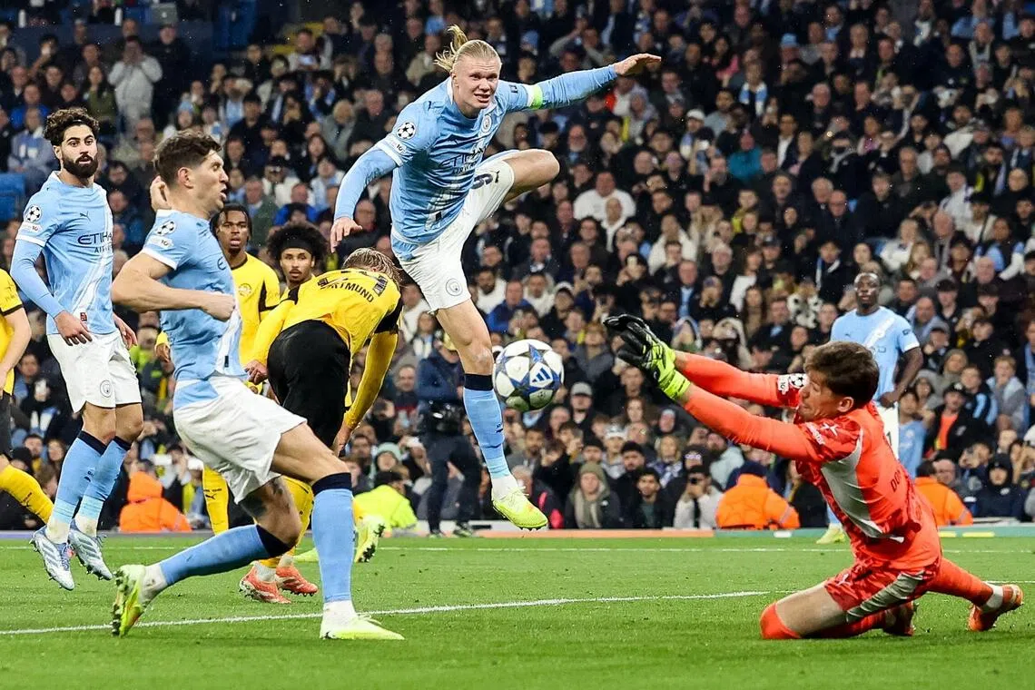 Manchester City's Erling Haaland (centre) and Borussia Dortmund goalkeeper Gregor Kobel (right) in action during the match.