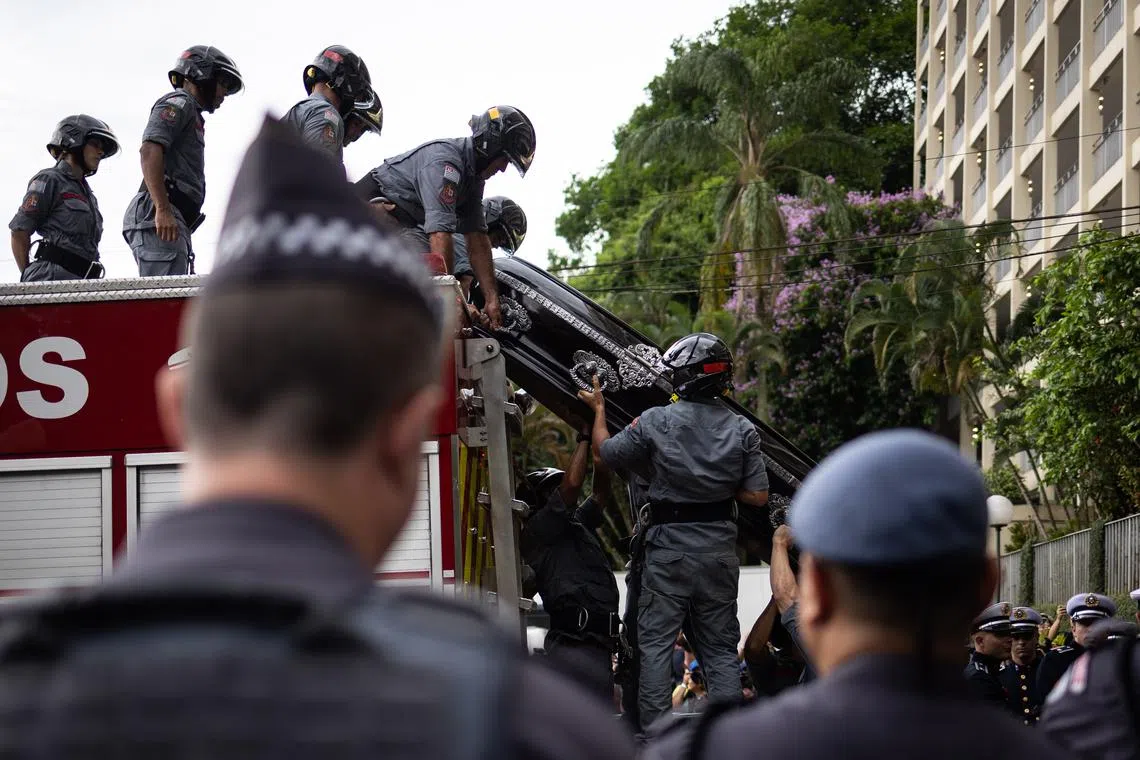 The casket of the late soccer legend Pele is unloaded from a fire truck as it arrives at a cemetery at the end of his funeral procession through the streets of Santos, Brazil, Jan 3, 2023. 