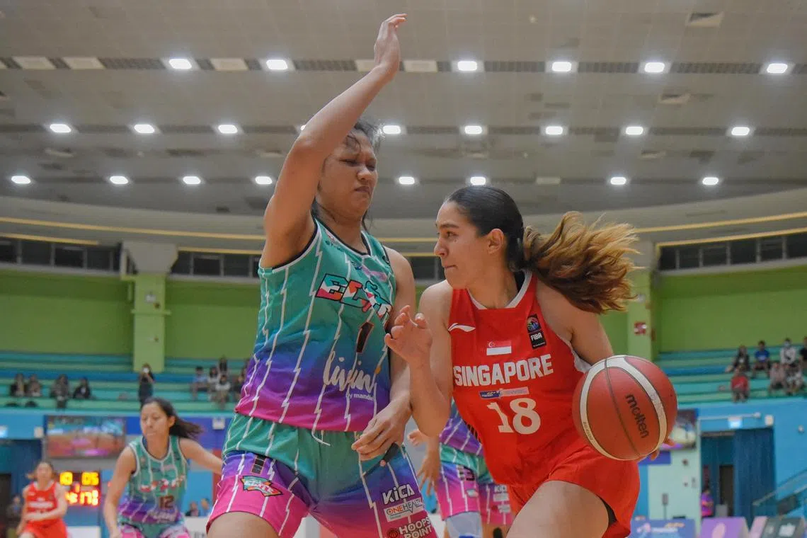 Singapore's Ariel Loiter (in red) driving against Indonesia's Dyah Lestari at the 2023 SEA Women Basketball League at Toa Payoh Sports Hall on Sunday.