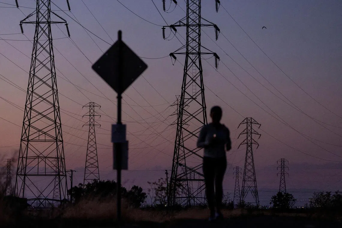 FILE PHOTO: A woman jogs by power lines in Mountain View, California, U.S., August 17, 2022. REUTERS/Carlos Barria/File Photo
