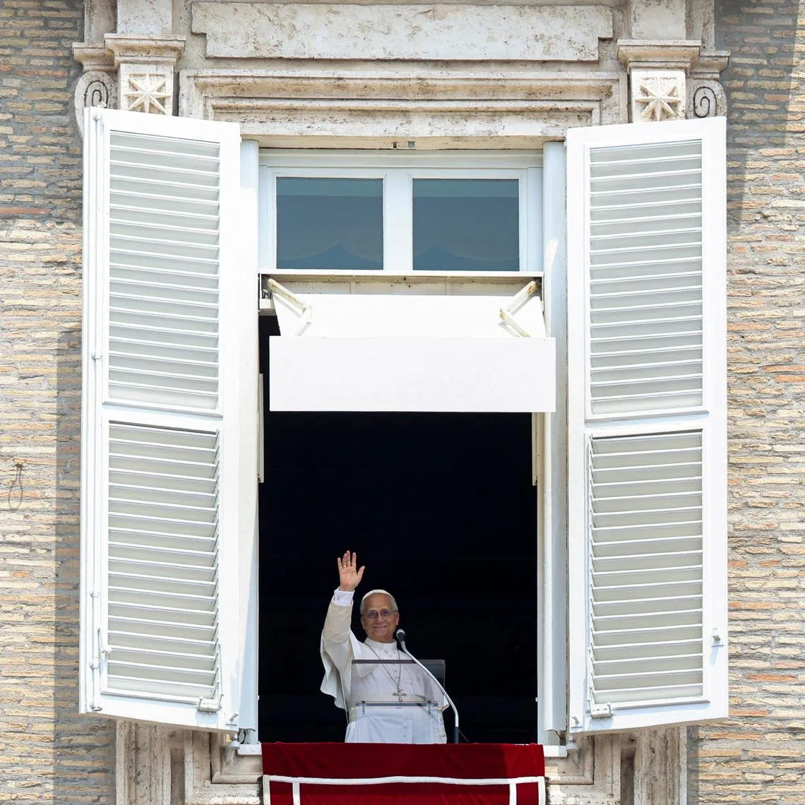 Pope Leo waving after leading the Angelus prayer from a window of the Apostolic Palace at the Vatican on June 29.