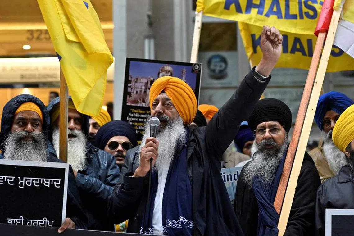 FILE PHOTO: A demonstrator uses a microphone as others hold flags and signs as they protest outside India's consulate, a week after Canada's Prime Minister Justin Trudeau raised the prospect of New Delhi's involvement in the murder of Sikh separatist leader Hardeep Singh Nijjar, in Vancouver, British Columbia, Canada September 25, 2023.  REUTERS/Jennifer Gauthier/File Photo
