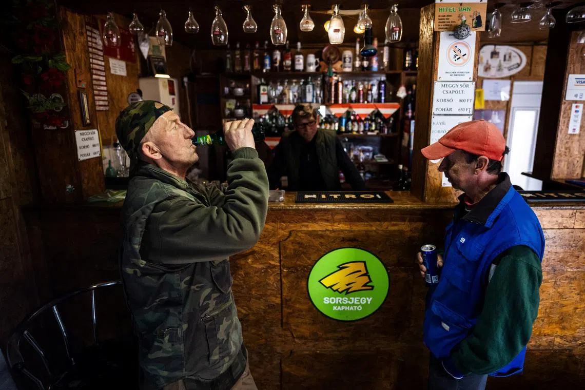 Sandor Toth, owner of Sanyi's Pub, talks to customers in Malyinka, Hungary, March 23, 2026. REUTERS/Marton Monus