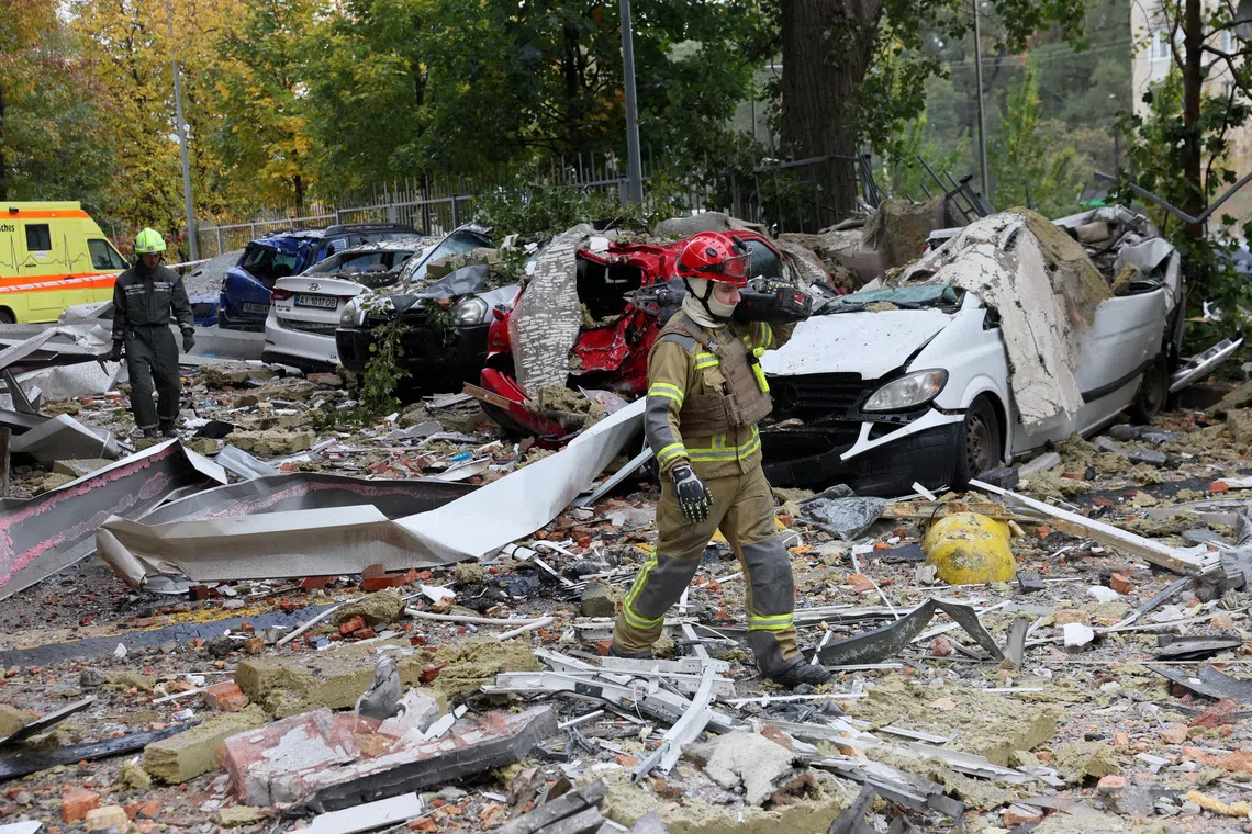 First responders walk on debris at the site of an apartment building, which was damaged during a Russian drone strike, amid Russia's attack on Ukraine, in Kyiv, Ukraine, October 21, 2026. REUTERS/Gleb Garanich