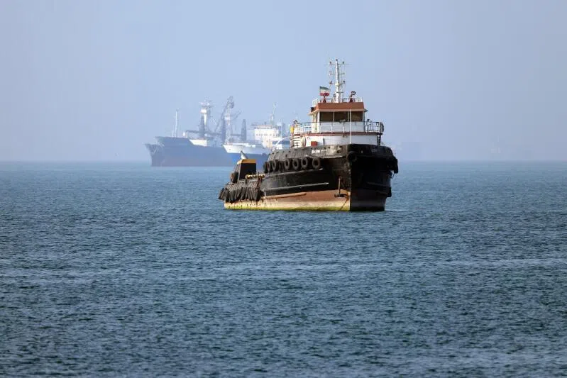 The Iran-flagged tugboat Basim sails near a ship anchored in the Strait of Hormuz off Bandar Abbas in southern Iran. 