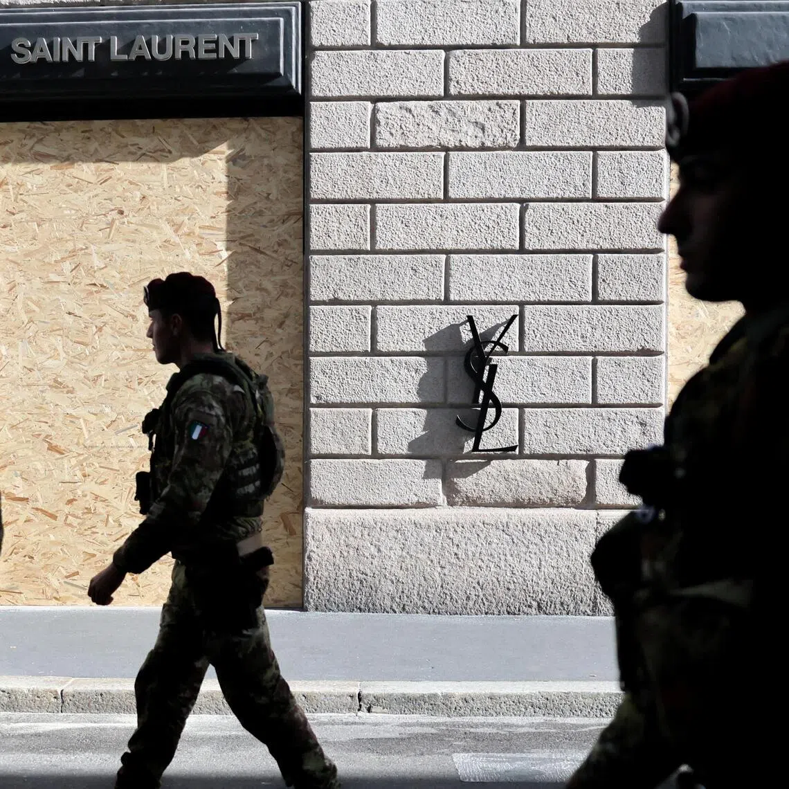 Members of the military walk by a boarded-up Saint Laurent store, ahead of a protest called by the October 17 Movement, in Milan, Italy, on Oct 24.