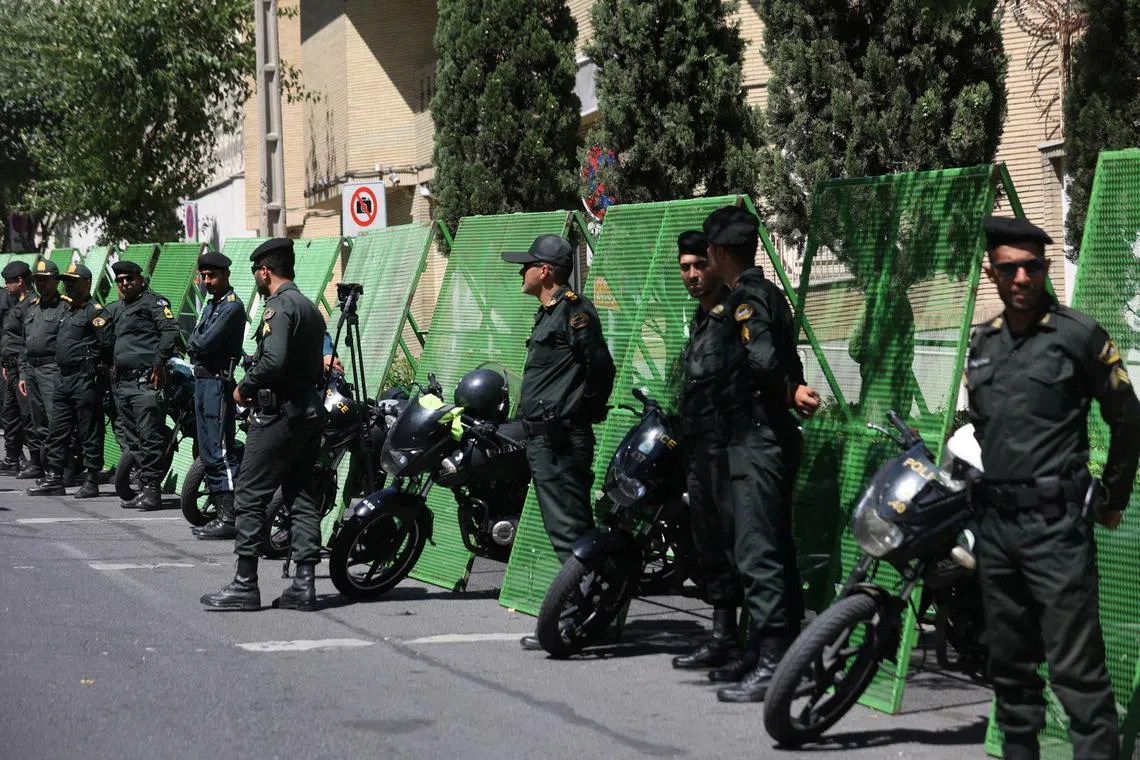 Police stand guard outside the Swedish Embassy in Teheran, on June 30.