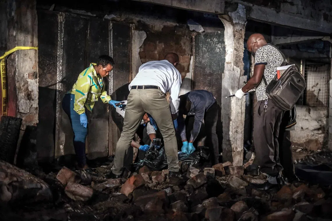 Forensic specialists and emergency responders seal a body bag containing a deceased person after a fuel truck explosion in Kigogwa, on October 22, 2024. A fuel truck ran out of control and exploded into flames near the Ugandan capital on October 22, 2024, killing at least 10 people. The disaster occurred on a highway in the town of Kigogwa, about 25 kilometres (15 miles) north of Kampala. (Photo by Badru KATUMBA / AFP)
