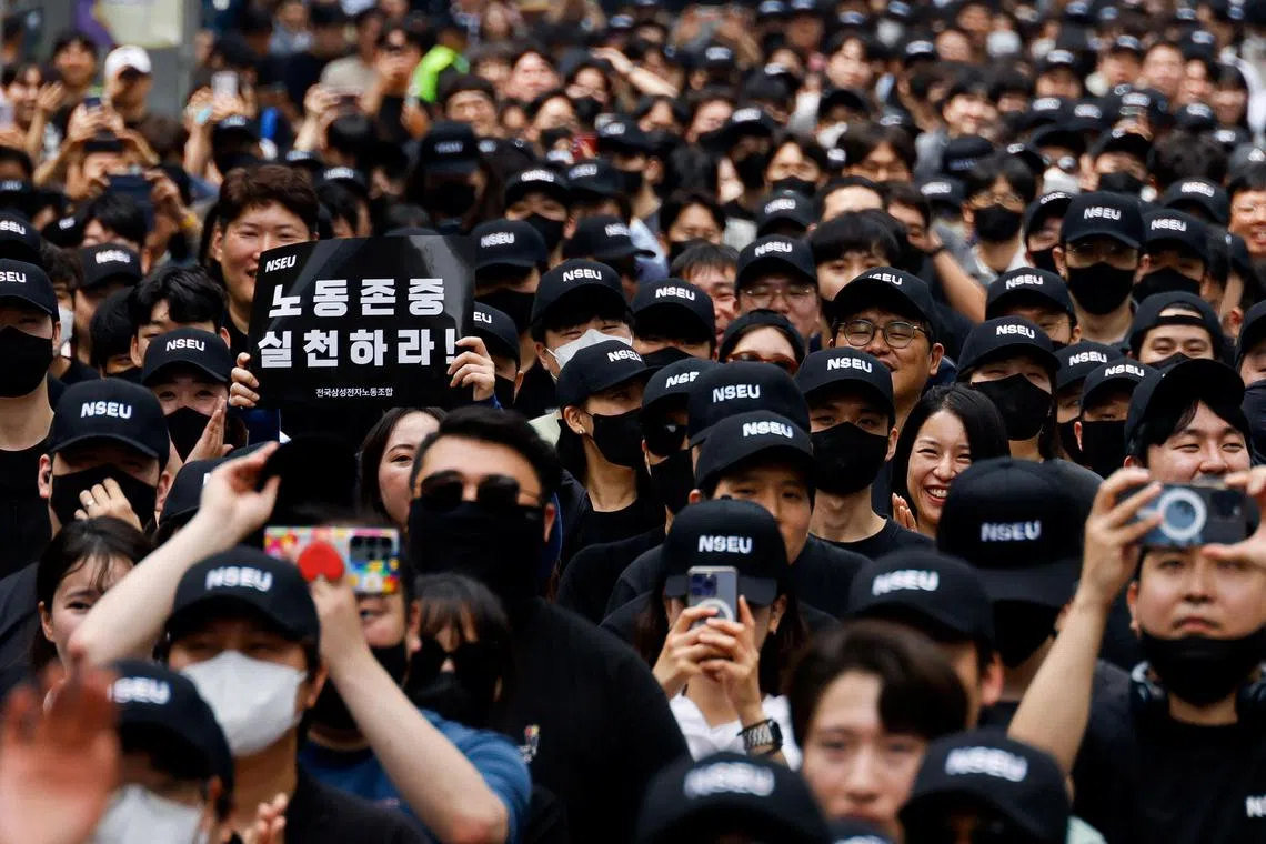 A member of the National Samsung Electronics Union (NSEU) holds a placard that reads "Respect labour" in front of the Samsung Electronics Seocho Building in Seoul on May 24.