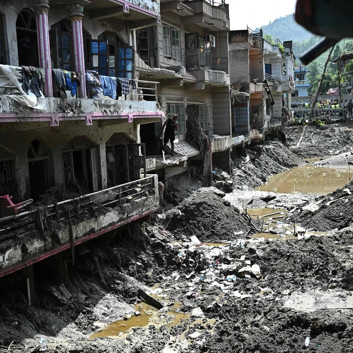 A man looks at the remains of sludge-ridden houses in the aftermath of flash floods at Devighat in Nepal’s Nuwakot district on Sept 8.