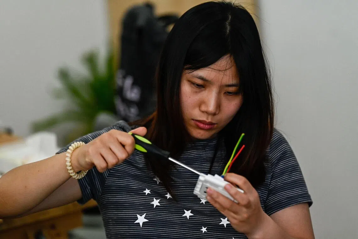 A woman practising during an electricity course at the Mulan Build workshop in Hangzhou on June 28.