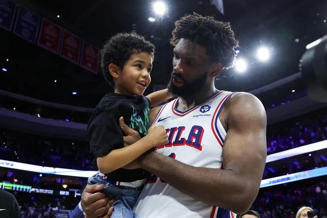 Philadelphia 76ers center Joel Embiid carries his son Arthur on the court after a victory against the Boston Celtics at Xfinity Mobile Arena. 
