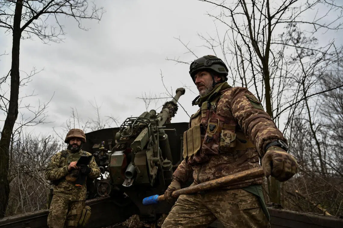 Ukrainian servicemen stand fire a howitzer towards Russian troops,  in Ukraine's Zaporizhzhia region, on Jan 5, 2022.