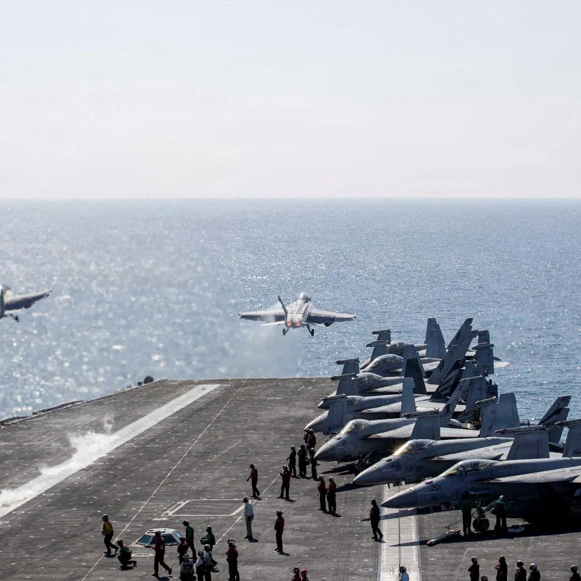 FILE PHOTO: Two F/A-18 Super Hornets launch from the flight deck of the U.S. Navy Nimitz-class aircraft carrier USS Abraham Lincoln in support of the Operation Epic Fury attack on Iran from an undisclosed location March 3, 2026. U.S. Navy/Handout via REUTERS/File Photo