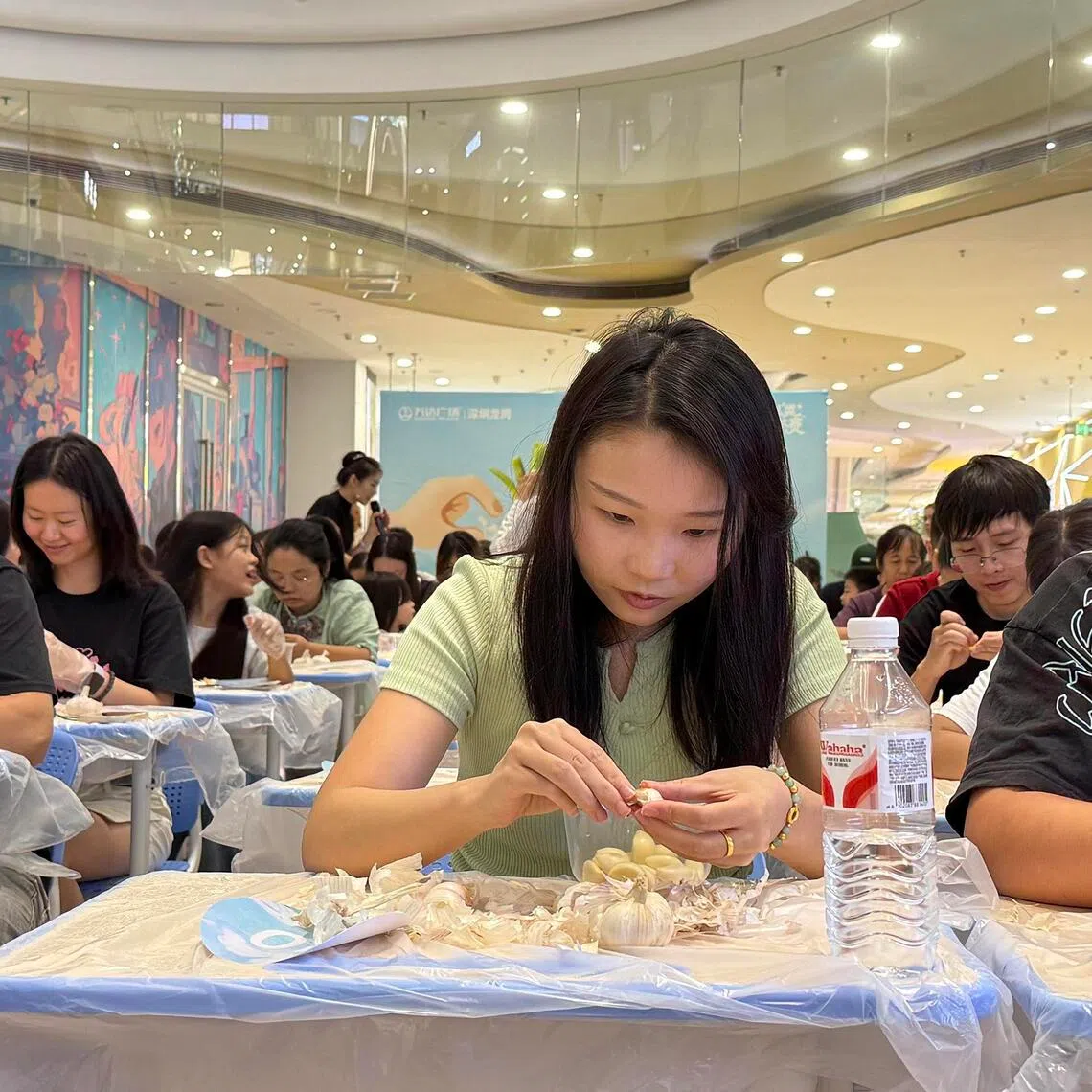 People participate in a garlic peeling contest at the Longgang Wanda Plaza in Shenzhen on Aug 8.
