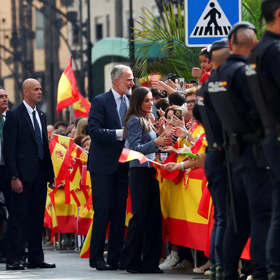 Spain's King Felipe and Queen Letizia greet people as they arrive to visit the Ceuta town hall and seat of government, in Ceuta, Spain, October 13, 2026. REUTERS/Pedro Nunes