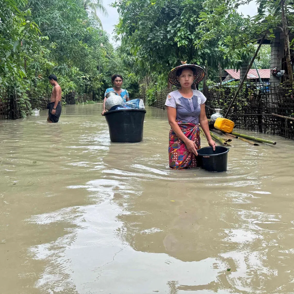 Residents wade through floodwaters in Kyauktaw, Myanmar’s western Rakhine state on July 10.