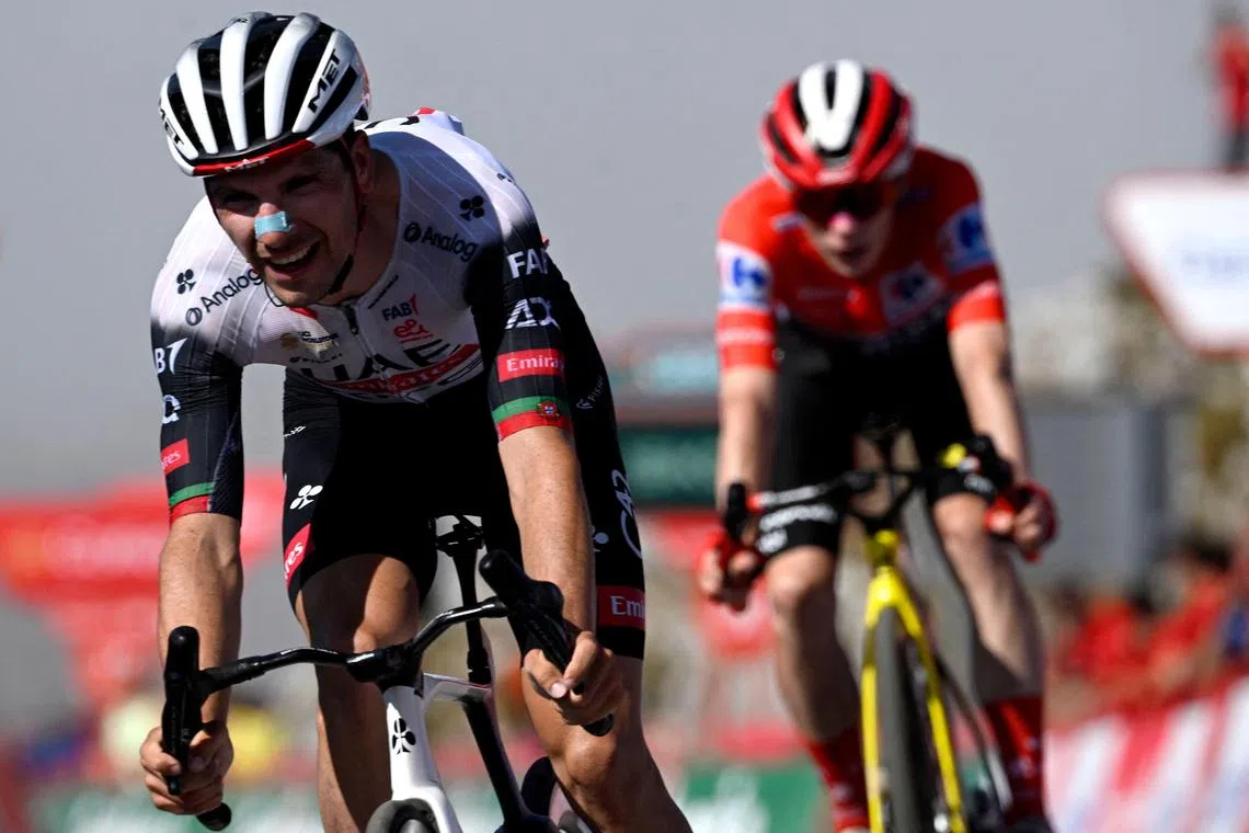 Team UAE's Portuguese rider Joao Almeida crosses the finish line of the 13th stage of the Vuelta a Espana, a 202km race between Cabezon de la Sal and L'Angliru, on Sept 5, 2025, followed by Danish rider Jonas Vingegaard, Team Visma-Lease a Bike's second-placed overall leader.
