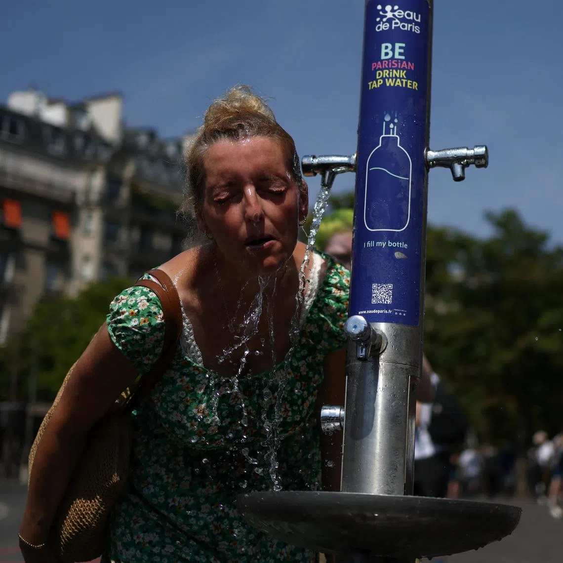 A woman cools off in a public fountain near the Place du Trocadero during high temperatures amid a heatwave in Paris, France, June 27, 2026. REUTERS/Tom Nicholson