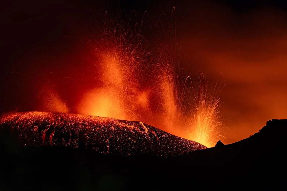 A photograph taken on July 6, 2026 shows lava flowing from the crater during an eruption of the Mount Etna volcano in Sicily. (Photo by Etna Walk / AFP)