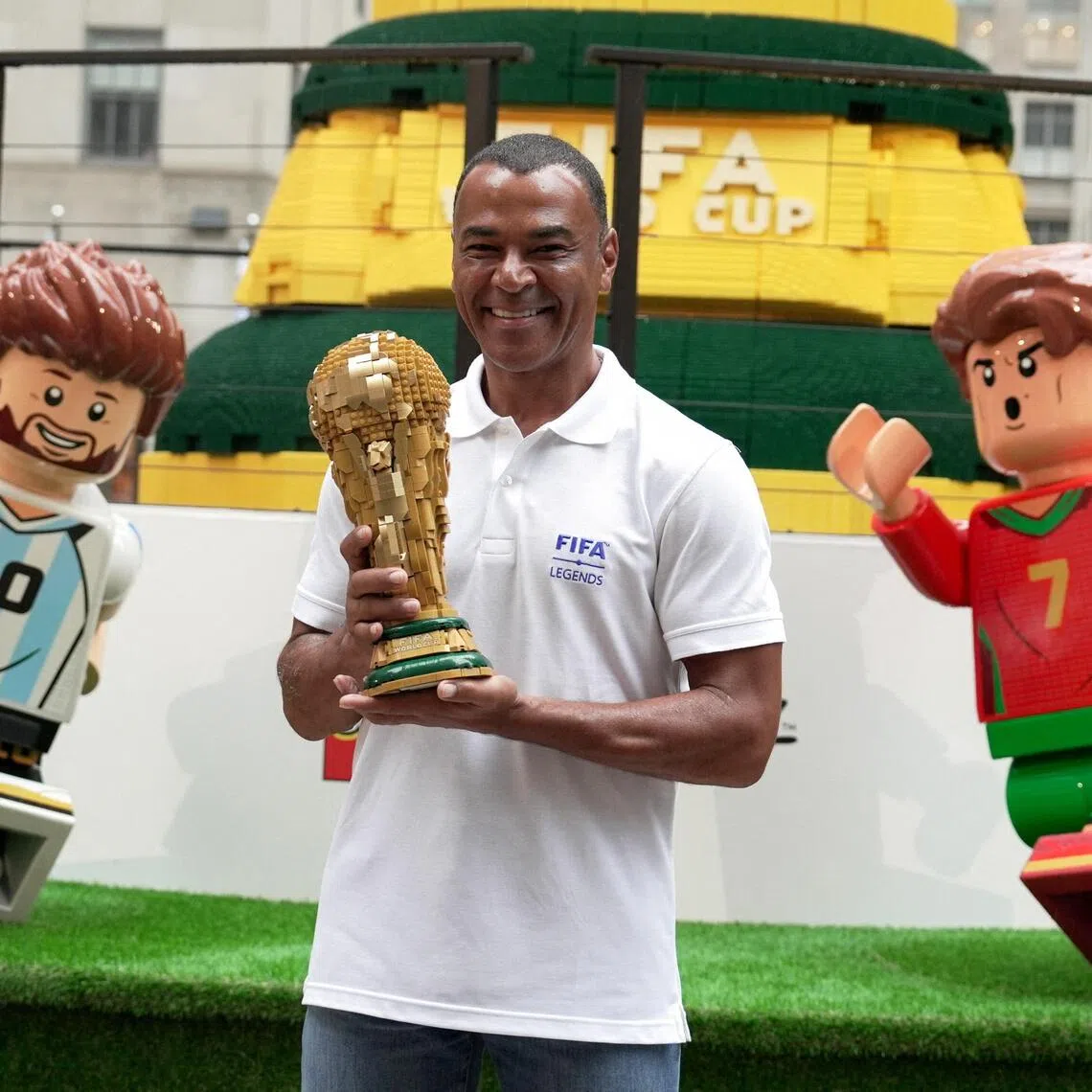 Former Brazil footballer Cafu holds a Lego World Cup trophy in front of a giant recreation of the trophy.