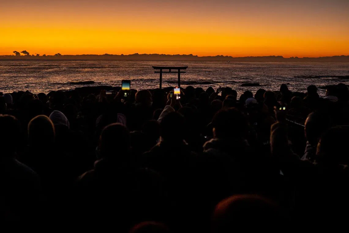People gather in front of the torii gate of Oarai Isosaki shrine to watch the sunrise on New Year's Day in Oarai of Ibaraki Prefecture on Jan 1, 2023. 