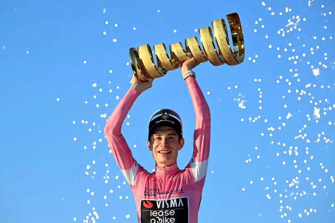 Team Visma-Lease a Bike's Jonas Vingegaard celebrates on the podium with the trophy, wearing the maglia rosa jersey, after winning the Giro d'Italia on May 31.