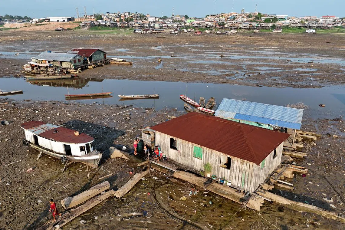 A drone view shows floating houses on a dry river in Igarape do Xidarinim during a drought season, in Tefe, in the state of Amazonas, in Brazil on Aug 20, 2024. 
