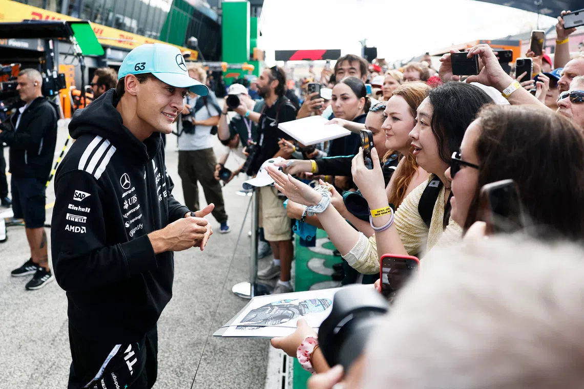 Formula One F1 - Dutch Grand Prix - Circuit Zandvoort, Zandvoort, Netherlands - August 20, 2026 Mercedes' George Russell with fans in the pitlane ahead of the Dutch Grand Prix REUTERS/Benoit Tessier